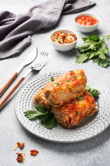 Cabbage rolls with beef, rice and vegetables on the plate. Stuffed cabbage leaves with meat. Gray concrete table