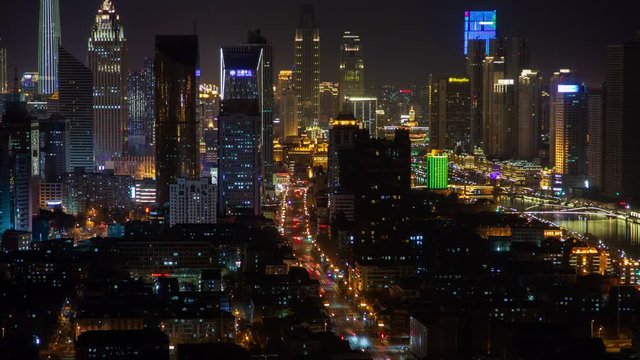 Timelapse flashing advertisements on Tianjin city highrise buildings in Chinese Heping District with wide highway and high skyscrapers at dark night