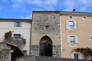 Fototapeta na wymiar Porte de ville dans la muraille en pierre du le village de Sauzet - Département de la Drôme - France