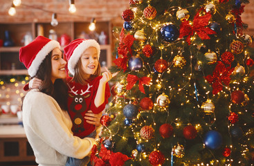 Fototapeta Little girl enjoying Christmas tree with her mom obraz