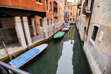 Fototapeta na wymiar 09.10.2019 Venice, Italy, City canal with moored motor boats and gondola.