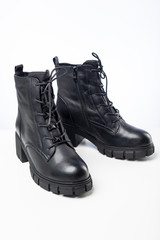women's black demi-season leather boots on white background