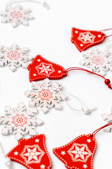 Decorations of Christmas tree wooden red and white snowflakes and bells with ornament. Background winter