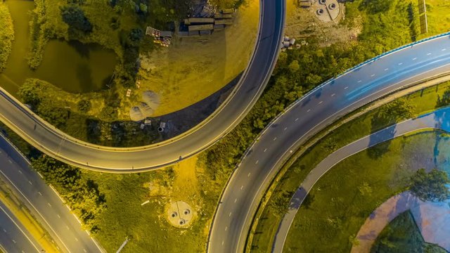 Hyperlapse timelapse of night city traffic on 4-way stop street intersection circle roundabout in bangkok, thailand. 4K UHD horizontal aerial view.