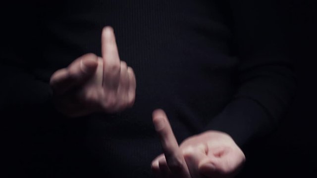 A man makes an obscene gesture showing the middle finger, close-up on a black background
