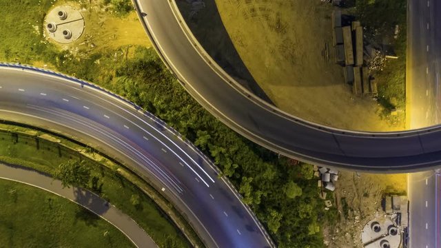 Hyperlapse timelapse of night city traffic on 4-way stop street intersection circle roundabout in bangkok, thailand. 4K UHD horizontal aerial view.