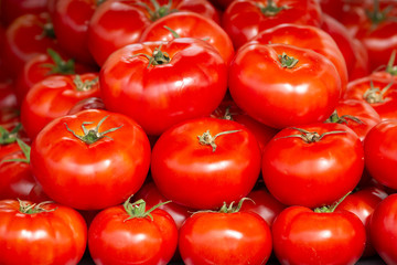 Close-up view of fresh juicy tomatoes, background photography. Summer agriculture farm market tray full of organic tomatoes