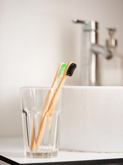 eco natural bamboo toothbrushes in glass. sustainable lifestyle concept. zero waste home. bathroom essentials, plastic free items