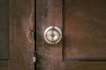 old stainless door knob or handle on grunge wooden door