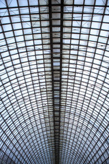 Double exposure of structural glazing. Generic modern architecture fragment with glass ceiling, roof or wall made of transparent facade panels. Abstract geometric background with complex grid pattern.