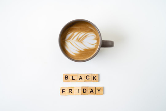 Black friday text on wooden blocks and cup of coffee. top view