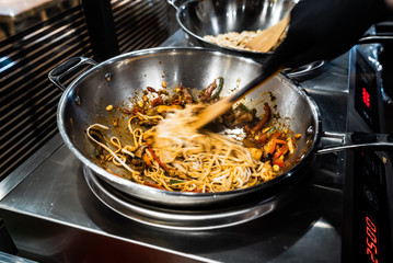 chef cooking noodles in the restaurant