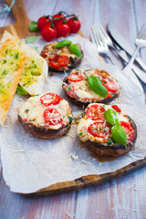 Grilled champignon portobello stuffed with mozzarella, cherry tomatoes and basil with garlic herb baguette