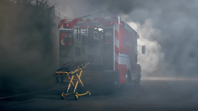 An empty ambulance with stretchers standing in dense smoke in the middle of road