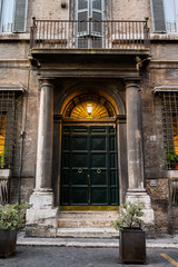 Fototapeta na wymiar Vintage house arched green door and foliage, Trastevere. Italy, Rome