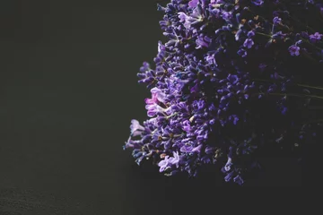 Ein schöner Lavendel auf einem schwarzen hölzernen Hintergrund. Dunkellila und blaue Lavendelblüten. © Struzhkova Ilona