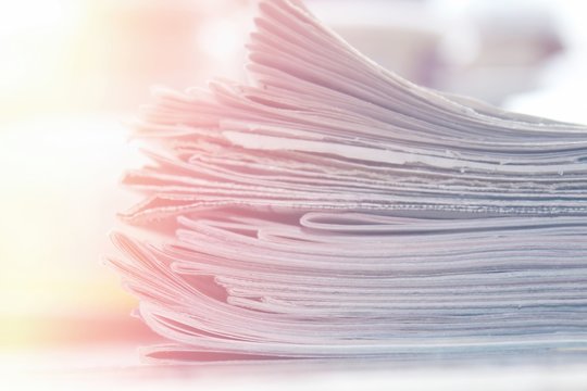 Stack of newspapers close up background, soft light