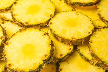 Pineapple juicy yellow slices background. Top view.