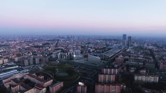 Milan, Italy. Aerial footage of the city during dusk time, with the skyscrapers in the mist.