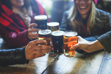 Group of happy friends drinking and toasting beer at brewery bar restaurant - Friendship concept...