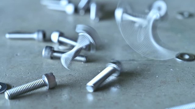 The 4K footage of the screws dropping on the cement floor. the concept of construction, mechanics, industrial and technology.