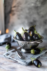 Group of fresh eggplant in a bowl on a wooden table, selective focus. Place for text. Copy space.