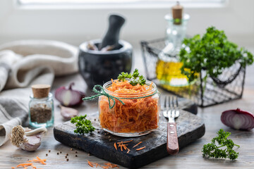 Grated fresh carrot salad with spices in a glass jar