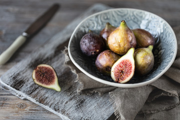 Fresh ripe figs in a bowl on a dark wooden table. selective focus