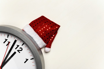 Clock with a Christmas cap on a white background