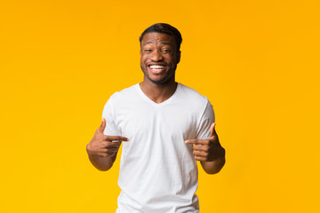 Black Man Pointing Fingers At Himself Smiling Over Yellow Background