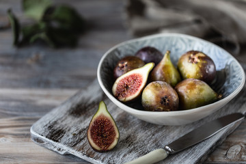Fresh ripe figs in a bowl on a dark wooden table. selective focus