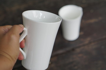 A white coffee cup held by hand for lovers