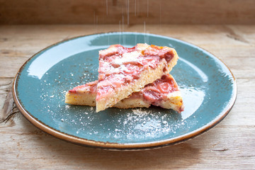 Round strawberry pie with fresh strawberries slice on plate dish on wooden table background