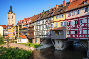 Classic panoramic view of ancient city center of Erfurt with famous Krämerbrücke bridge, colorful houses and historic St Giles' Church on a sunny day with blue sky in summer, Thuringia, Germany