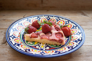 Round strawberry pie with fresh strawberries slice on plate dish on wooden table background