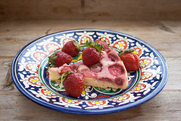 Round strawberry pie with fresh strawberries slice on plate dish on wooden table background