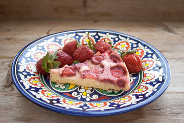 Round strawberry pie with fresh strawberries slice on plate dish on wooden table background