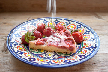 Round strawberry pie with fresh strawberries slice on plate dish on wooden table background