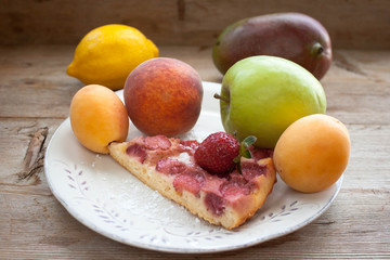 Round strawberry pie with fresh strawberries slice on plate dish on wooden table background
