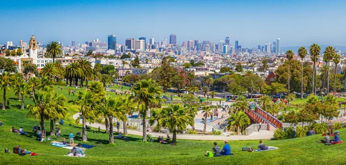 Poster Im Rahmen Panoramic view of local people enjoying the sunny summer weather at Mission Dolores Park on a beautiful day with clear blue sky with the skyline of San Francisco in the background, California, USA © Shambhala