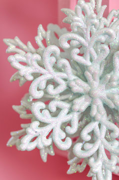 Large white snowflake on a pink background