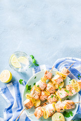 Homemade salmon fish grilled skewers, with lemon and greens