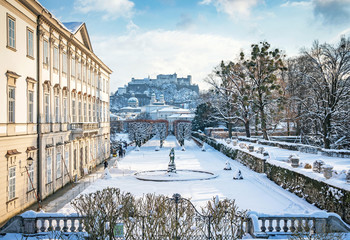 Classic view of famous Mirabell Gardens in the historic city of Salzburg with Hohensalzburg Fortress in golden evening light on a beautiful sunny day with blue sky in winter, Salzburger Land, Austria - obrazy, fototapety, plakaty