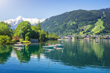 Scenic panoramic view of idyllic Zeller lake with old town Zell am See and snow-capped alpine mountain top Kitzsteinhorn on a beautiful sunny day with blue sky in springtime, Salzburger Land, Austria