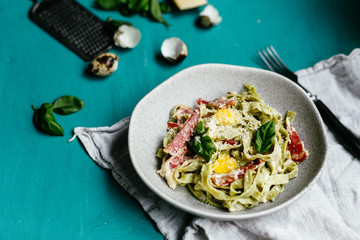 Green carbonara pasta with spinach in a gray plate