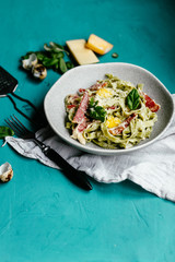 Green carbonara pasta with spinach in a gray plate