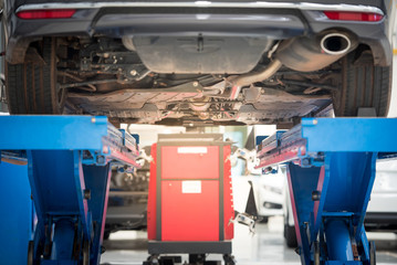 Car mechanic installing sensor during suspension adjustment. Wheel alignment work at repair service station