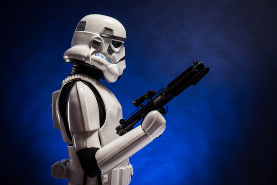 SAN BENEDETTO DEL TRONTO, ITALY. NOVEMBER 11, 2017. Studio portrait  of stormtrooper costume replica, with blaster E-11 gun. He is a fictional character of Star Wars saga. Blue background with smoke