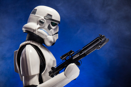 SAN BENEDETTO DEL TRONTO, ITALY. NOVEMBER 11, 2017. Studio portrait  of stormtrooper costume replica, with blaster E-11 gun. He is a fictional character of Star Wars saga. Blue background with smoke