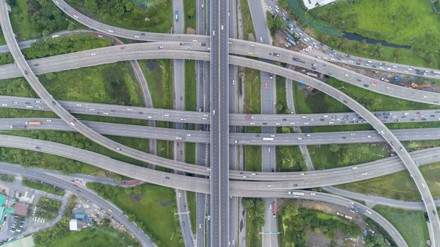 Hyperlapse timelapse of night city traffic on 4-way stop street intersection circle roundabout in bangkok, thailand. 4K UHD horizontal aerial view.